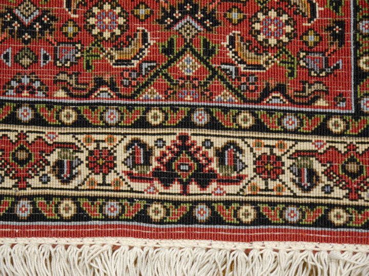 Makroaufnahme der Bidjar-Tekab-Bordüre bei ca. 400.000–500.000 Knoten/m² mit einzeln erkennbaren Knoten im Elfenbeinband und Herati-Feld darüber
