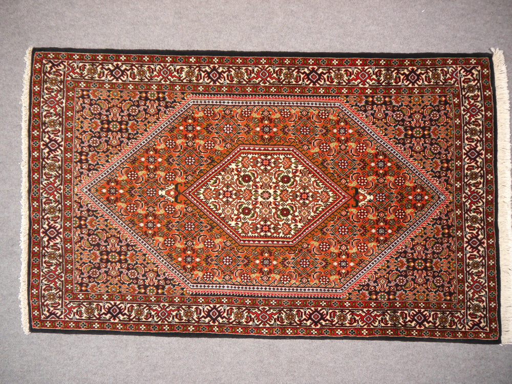 Bidjar Teppich flach ausgelegt, die drei Zonen der Komposition sichtbar: Elfenbein-Medaillon, rostoranges Feld und marineblaue Eckzwickel