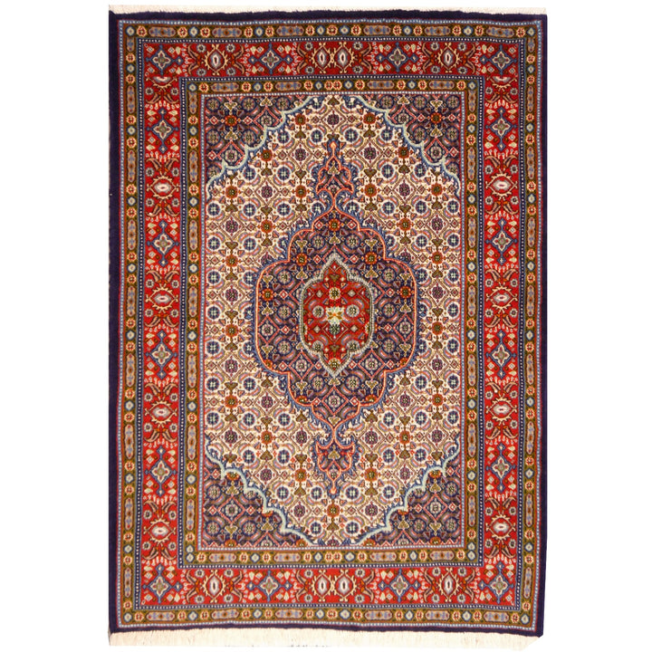 Perserteppich Moud Birdjand, 141 × 103 cm, gezacktes dunkelblaues Medaillon mit rotem Kern auf Elfenbein-Mahi-Feld, krapprote Palmettenbordüre — Gesamtansicht