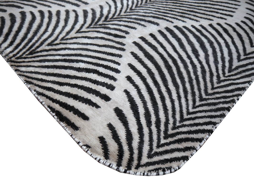 Fanned zebra stripes of the Art Deco rug in anthracite on grey-white bamboo silk | 15756