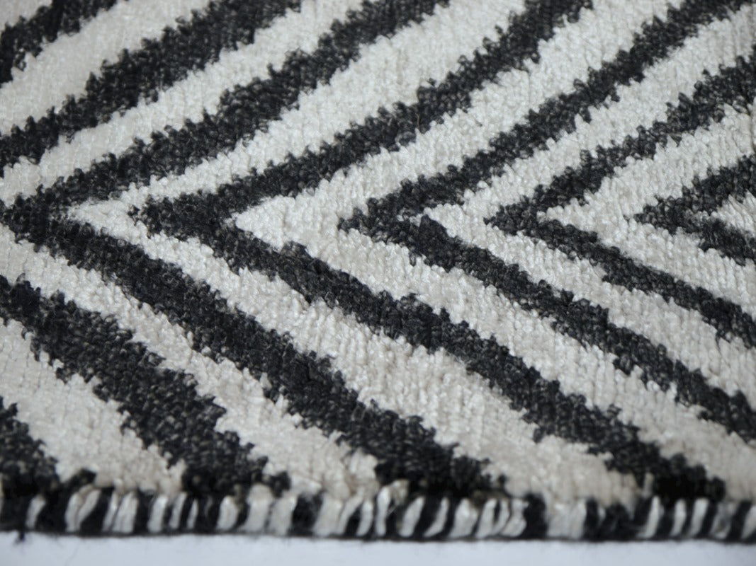 Close-up of the bamboo silk pile, ivory ground catching the light against matte anthracite | 15756